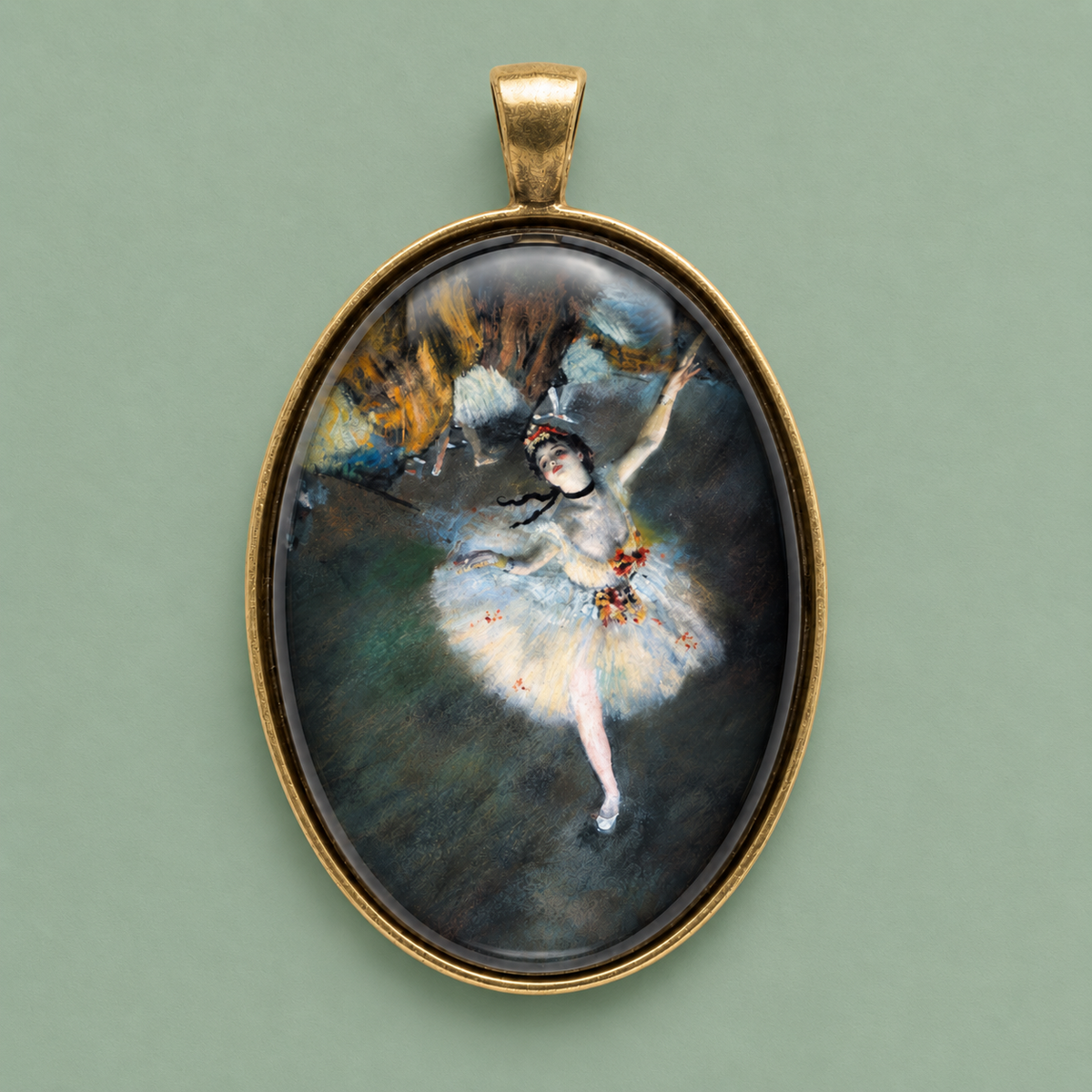 Edgar Degas ballet medallion pendant in glass and antique brass, 40x30 mm, photographed on a muted sage green background.